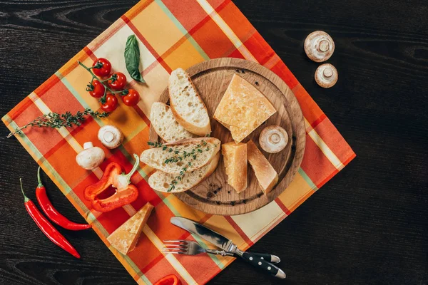 Vue du dessus du pain et du fromage parmesan sur planche de bois — Photo de stock