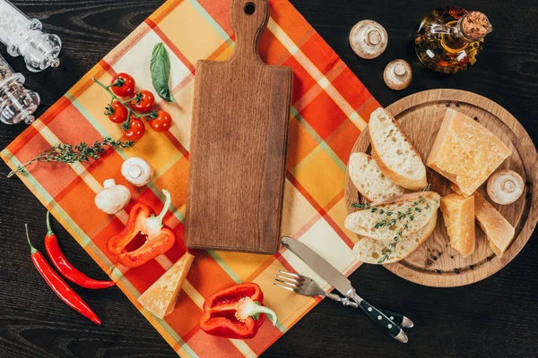 Vue du dessus des planches à découper avec légumes et fromage parmesan sur la table — Photo de stock