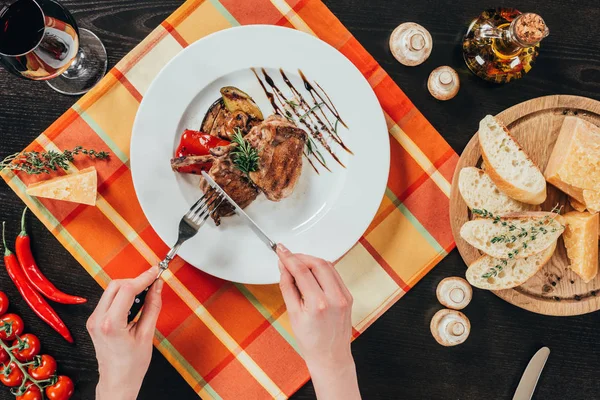 Imagen recortada de mujer cortando pedazo de pollo a la parrilla - foto de stock