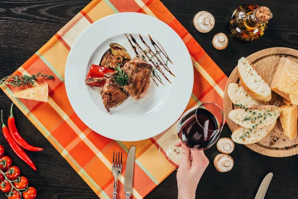 Imagem cortada de mulher segurando copo de vinho tinto — Fotografia de Stock