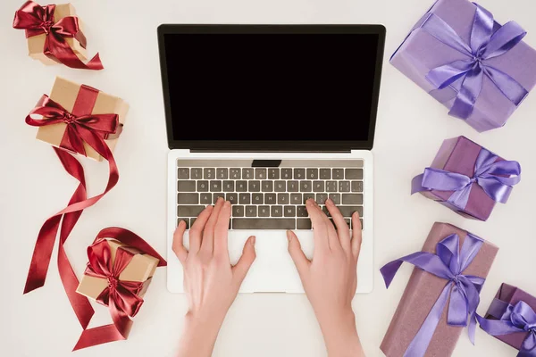 Top view of businesswoman hands on laptop between gift boxes — Stock Photo