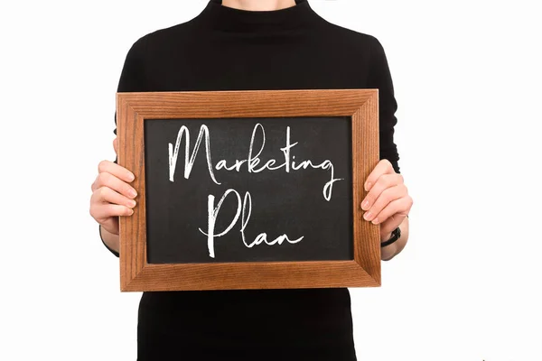 Partial view of woman holding board with lettering marketing plan isolated on white — Stock Photo
