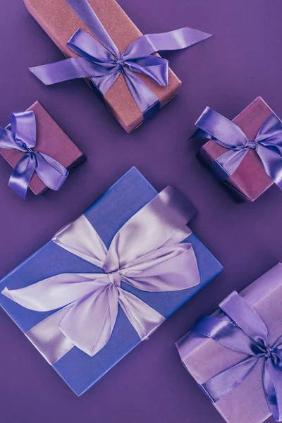 Top view of decorative gift boxes with ribbons and bows on purple — Stock Photo