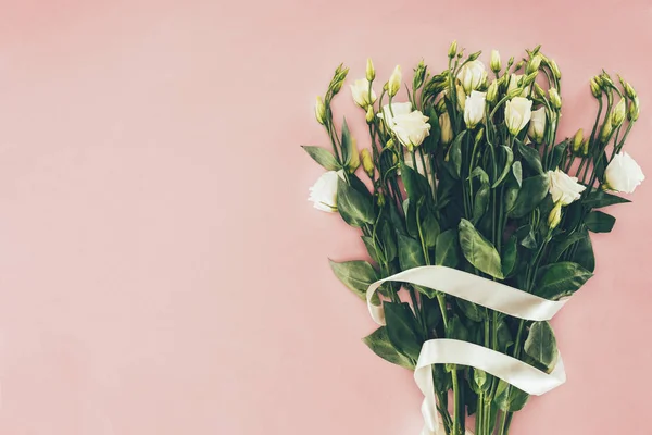 Ramo de hermosas flores blancas con hojas verdes y cinta en rosa - foto de stock