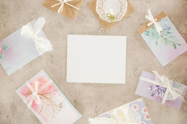 Vue du dessus du papier vierge entouré de cartes de vœux sur une surface en béton — Photo de stock