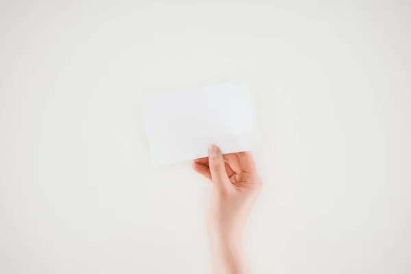 Recortado disparo de la mujer sosteniendo hoja en blanco de papel aislado en blanco - foto de stock