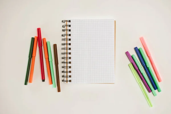 Vista superior del cuaderno en blanco con marcadores de colores aislados en blanco - foto de stock