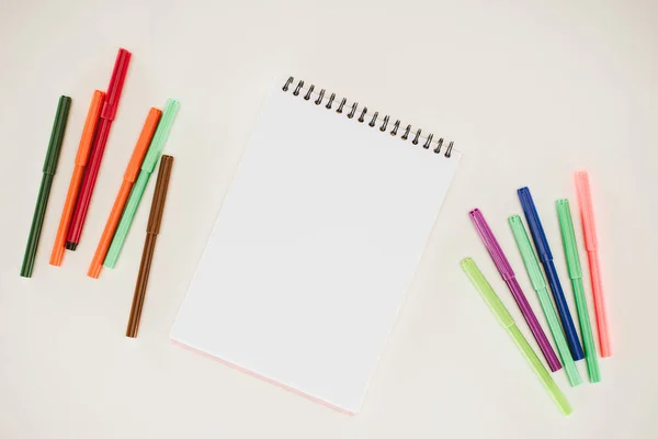 Vue du dessus du bloc-notes vierge avec des marqueurs colorés isolés sur blanc — Photo de stock