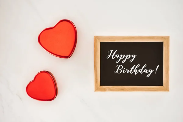 Top view of blackboard in frame with HAPPY BIRTHDAY lettering with heart shaped isolated on white — Stock Photo