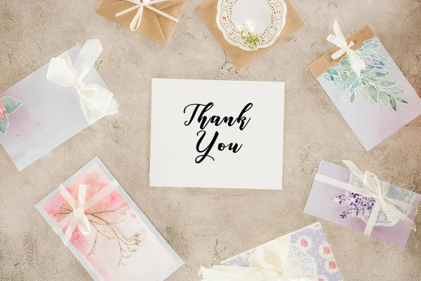 Top view of paper with  lettering surrounded with greeting cards on concrete surface — Stock Photo