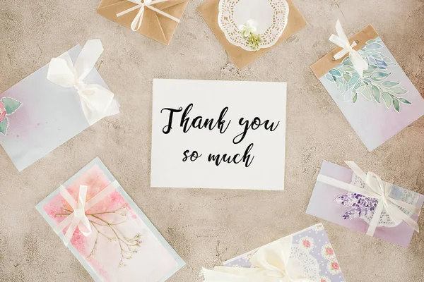 Top view of paper with thank you lettering surrounded with greeting cards on concrete surface — Stock Photo