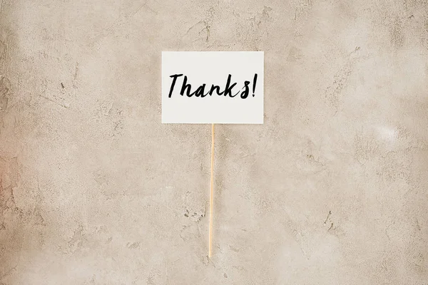 Top view of thanks lettering on placard on concrete surface — Stock Photo