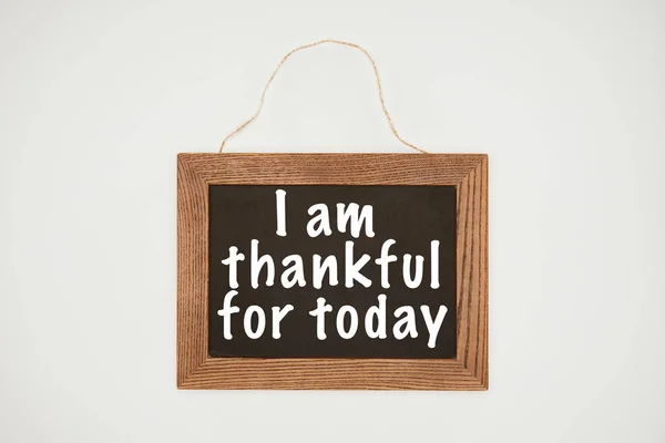 I am thankful today lettering on chalkboard with wooden frame and thread isolated on white — Stock Photo