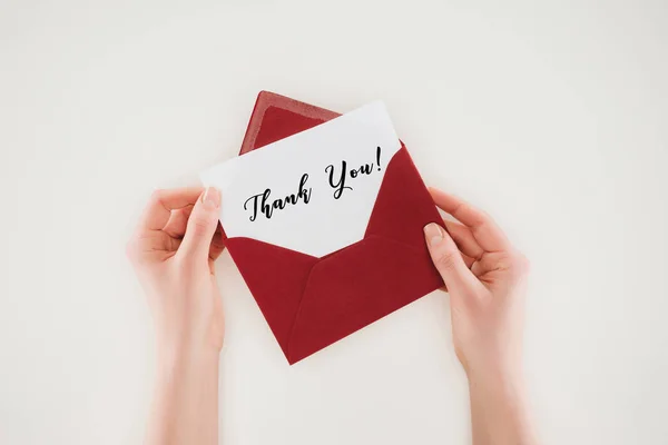 Cropped shot of woman opening red envelope with thank you lettering on paper isolated on white — Stock Photo