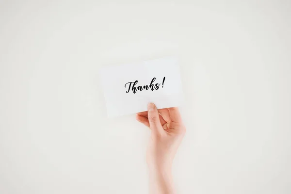 Cropped shot of woman holding paper with thanks lettering isolated on white — Stock Photo