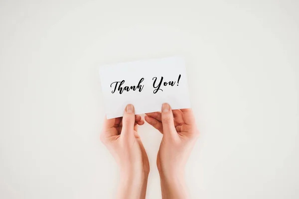 Cropped shot of woman holding paper with thank you lettering in hands isolated on white — Stock Photo