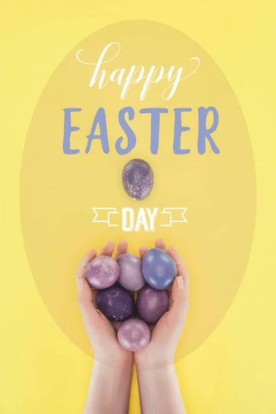 Cropped view of woman holding painted easter eggs in hands with happy easter day lettering — Stock Photo