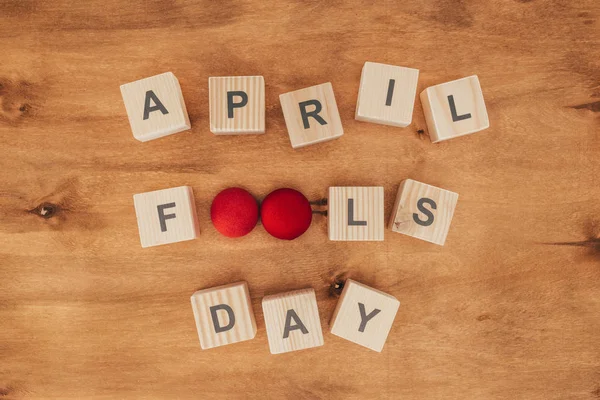 Top view of arranged wooden cubes in april fools day lettering on wooden tabletop, 1 april holiday concept — Stock Photo