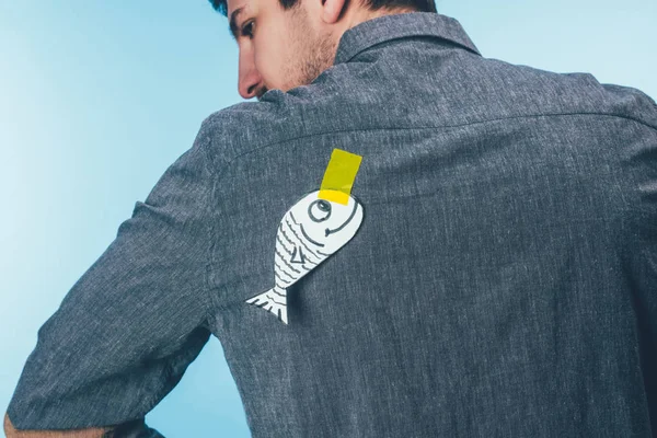 Rückansicht Mann mit Fisch auf Klebeband auf dem Rücken, Aprilscherz-Urlaubskonzept — Stockfoto