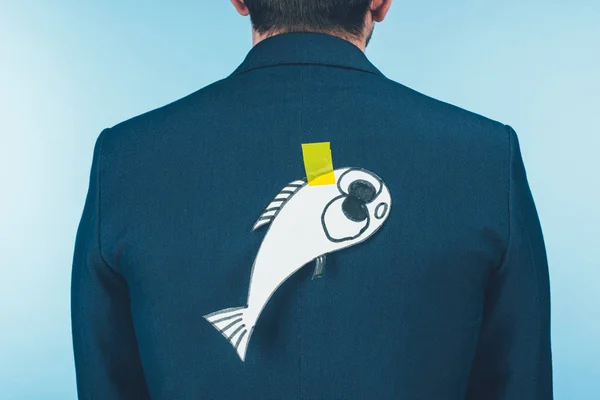 Rückseite Geschäftsmann im Anzug mit Fisch aus Papier auf dem Rücken, Aprilscherz-Konzept — Stockfoto