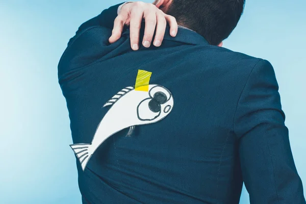 Back view of businessman in suit with paper made fish on back, april fools day concept — Stock Photo