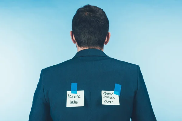 Vista posterior del hombre de negocios en traje notas con letras en la espalda, abril tontos concepto de día - foto de stock