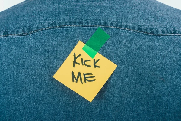 Primo piano vista di nota con kick me lettering sulla camicia jeans, aprile sciocchi concetto giorno — Foto stock