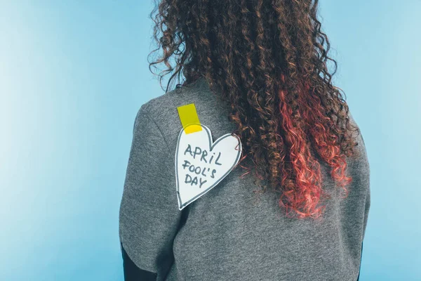 Back view of woman with heart on sticky tape with april fools day lettering on back, april fools day concept — Stock Photo