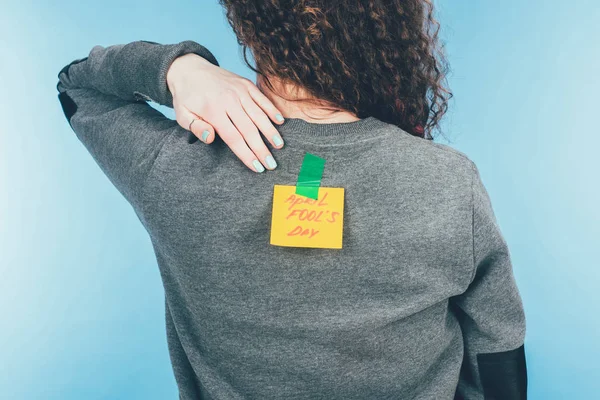 Back view of woman with note on sticky tape with april fools day lettering on back, april fools day concept — Stock Photo