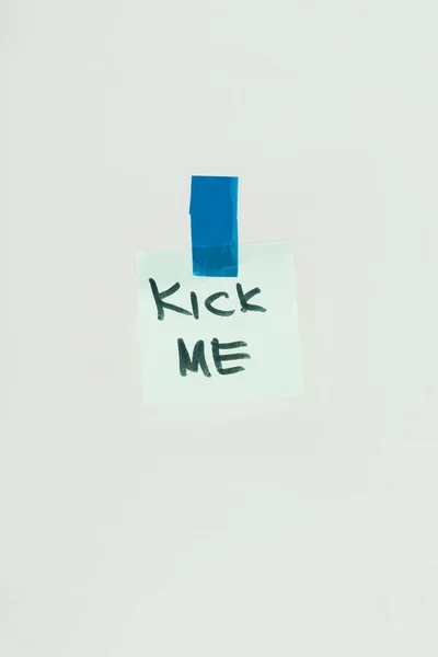 Close up view of note with kick me lettering and sticky tape isolated on grey, april fools day concept — Stock Photo