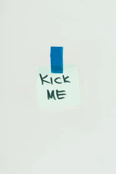 Primo piano vista di nota con kick me lettering e nastro adesivo isolato su grigio, aprile sciocchi concetto giorno — Foto stock