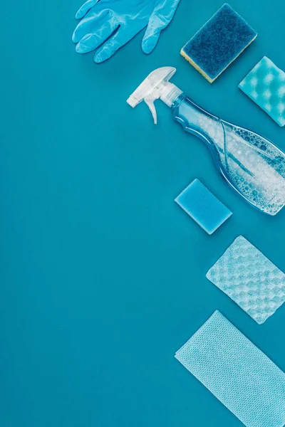 Top view of washing sponges and spray bottle for cleaning isolated on blue — Stock Photo