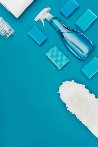 Top view of spray bottle, washing sponges and dust brush isolated on blue — Stock Photo