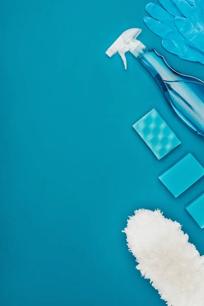 Vista superior de luvas de borracha e esponjas de lavagem para limpeza isoladas em azul — Fotografia de Stock