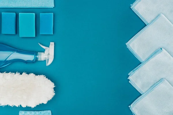 Top view of row of blue rags and cleaning supplies isolated on blue — Stock Photo