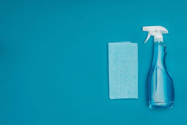 Draufsicht auf blauen Lappen und Sprühflasche isoliert auf blau — Stockfoto