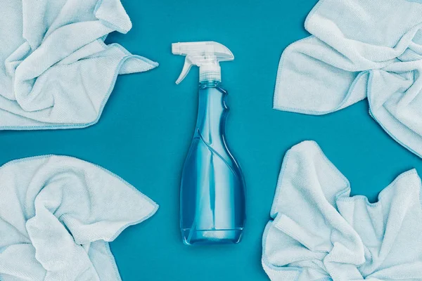 Top view of spray bottle and rags isolated on blue — Stock Photo