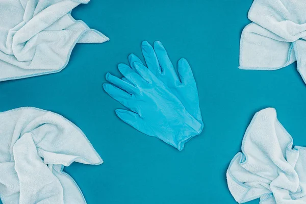 Top view of rubber gloves and rags isolated on blue — Stock Photo