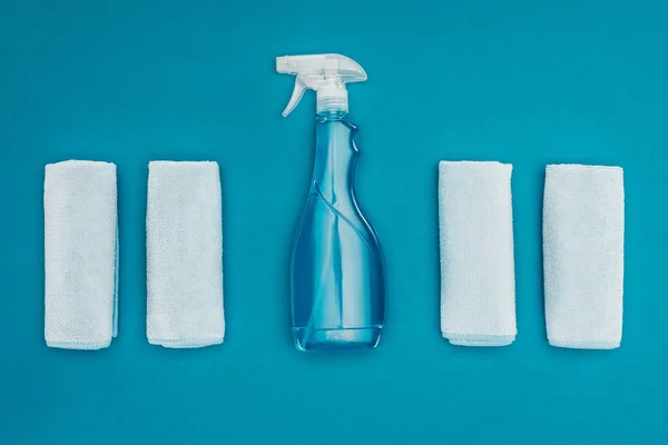 Top view of rags and spray bottle isolated on blue — Stock Photo