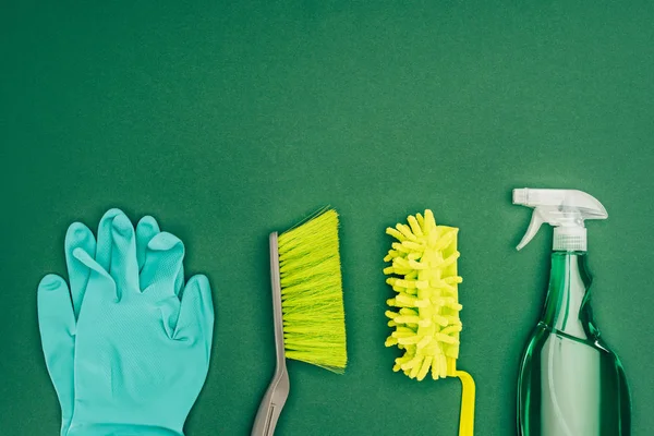 Ansicht von Gummihandschuhen und Bürsten isoliert auf grün — Stockfoto