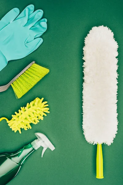 Vue de dessus de la brosse à poussière et des produits de nettoyage isolés sur vert clair — Photo de stock