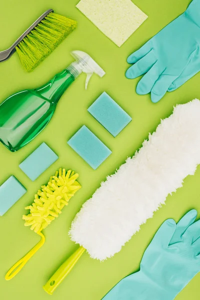 Top view of cleaning supplies isolated on light green — Stock Photo