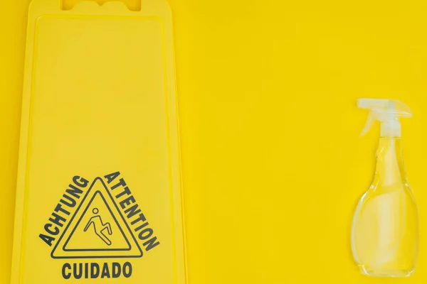 Draufsicht auf Nassbodenschild und Sprühflasche isoliert auf gelb — Stockfoto