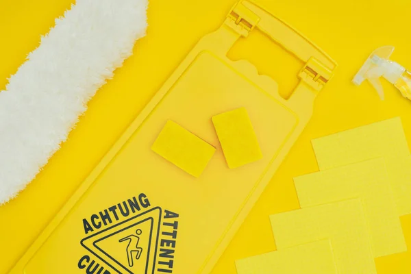 Top view of wet floor sign and washing sponges isolated on yellow — Stock Photo