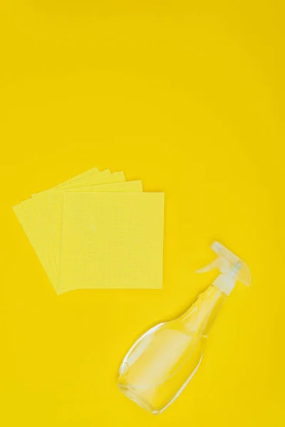 Підвищений вид на жовті ганчірки і пляшку розпилення ізольовані на жовтому — стокове фото