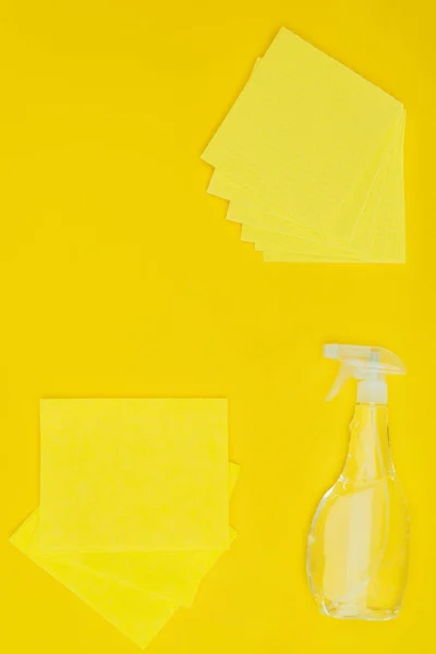 Vista superior de trapos amarillos y botella de spray aislado en amarillo - foto de stock