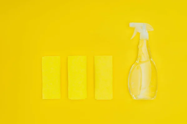 Vue du dessus des chiffons et de la bouteille isolée sur jaune — Photo de stock