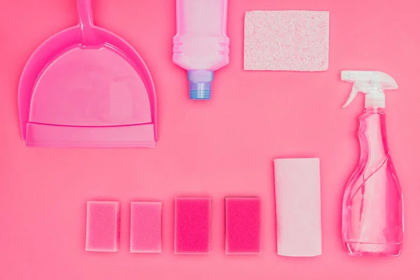 Vista superior de esponjas de lavado y líquidos de limpieza aislados en rosa - foto de stock