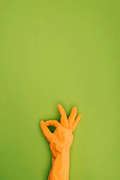 Imagem cortada da mulher mostrando sinal ok na luva de borracha protetora isolada no verde — Fotografia de Stock