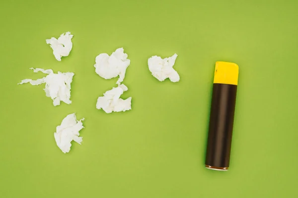 Top view of spray bottle and crumpled napkins isolated on green — Stock Photo